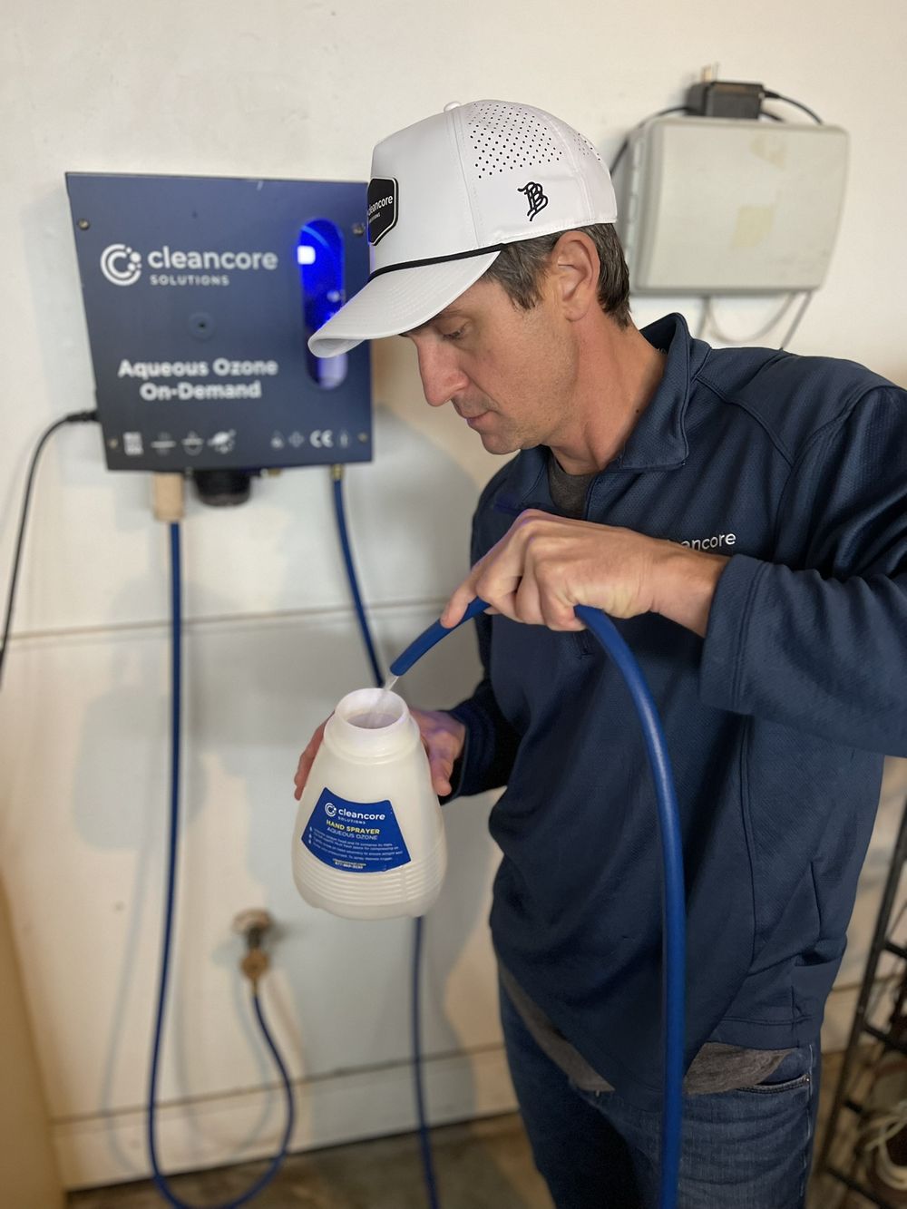 Man filling a spray bottle at the CleanCore Fill Station