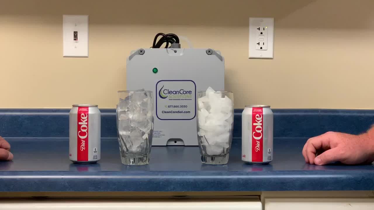 Two glasses of ice and soda cans on a counter